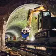 Ein 8-t-Bagger mit einer Kemroc-Diamantsäge KDS 30 fährt auf einem Plattformwagen in den Elleringhauser Tunnel ein. Seine Aufgabe bestand darin, Beton-Kabelkanäle am Tunnelfuß zu zerschneiden. Quelle: Kemroc

