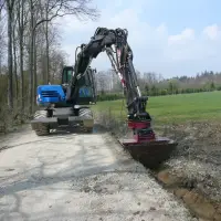 Die Kombination von RotoTop und VarioLöffel sorgt für den effizienten Bau von Gräben neben Straßen und Wegen – als wichtige Hochwasserschutzmaßnahme.
Die Kombination von RotoTop und VarioLöffel sorgt für den effizienten Bau von Gräben neben Straßen und Wegen – als wichtige Hochwasserschutzmaßnahme.